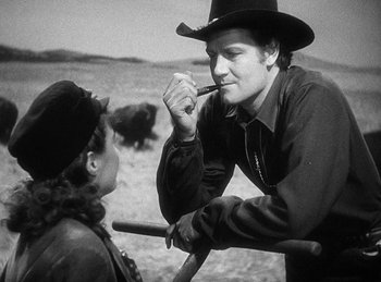 Movie still from “Union Pacific” (1939), directed by Cecil B. DeMille – A man and a woman talking to each other in a field; Medium shot, Over the shoulder angle