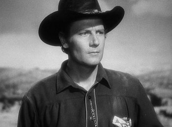 Movie still from “Union Pacific” (1939), directed by Cecil B. DeMille – A black and white photo of a man wearing a cowboy hat; Close Up shot, Low angle