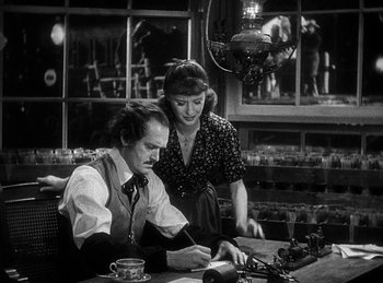 Movie still from “Union Pacific” (1939), directed by Cecil B. DeMille – A man and a woman sitting at a table in a restaurant; Medium shot, High angle