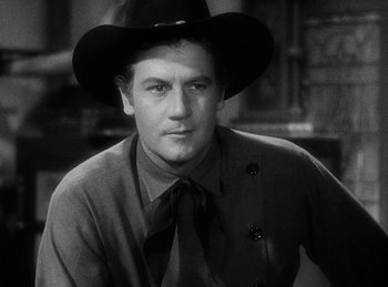 Movie still from “Union Pacific” (1939), directed by Cecil B. DeMille – A black and white photo of a man wearing a cowboy hat; Close Up shot, Over the shoulder angle