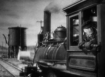 Movie still from “Union Pacific” (1939), directed by Cecil B. DeMille – An old fashioned steam engine with a man sitting on the front of it; Medium shot, Low angle