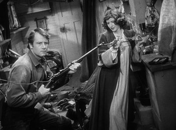 Movie still from “Union Pacific” (1939), directed by Cecil B. DeMille – A man and a woman are playing a video game together; Medium shot, Over the shoulder angle