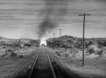 Movie still from “Union Pacific” (1939), directed by Cecil B. DeMille – A train traveling down train tracks next to power lines; Extreme Wide shot, High angle