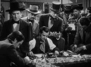 Movie still from “Union Pacific” (1939), directed by Cecil B. DeMille – A black and white photo of a group of men sitting at a table; Medium shot, High angle