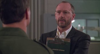 Movie still from “Universal Soldier: The Return” (1999), directed by Mic Rodgers – A man holding a clipboard talking to another man; Close Up shot, Over the shoulder angle