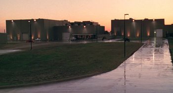 Movie still from “Universal Soldier: The Return” (1999), directed by Mic Rodgers – A view of a parking lot at sunset; Extreme Wide shot, Low angle