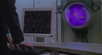 Movie still from “Universal Soldier: The Return” (1999), directed by Mic Rodgers – A computer monitor and keyboard in front of a purple light; Medium shot, Low angle