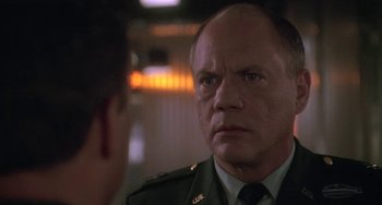 Movie still from “Universal Soldier: The Return” (1999), directed by Mic Rodgers – A man in a military uniform looking at another man in a uniform; Close Up shot, Over the shoulder angle