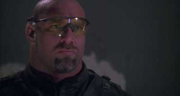 Movie still from “Universal Soldier: The Return” (1999), directed by Mic Rodgers – A man wearing safety glasses in a dark room; Close Up shot, Low angle