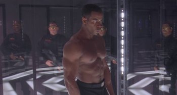 Movie still from “Universal Soldier: The Return” (1999), directed by Mic Rodgers – A man that is standing in a room; Medium shot, Low angle