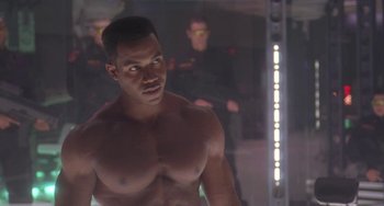 Movie still from “Universal Soldier: The Return” (1999), directed by Mic Rodgers – A man that is standing in a room; Medium shot, Over the shoulder angle