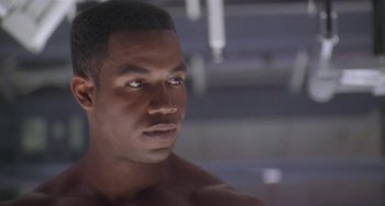 Movie still from “Universal Soldier: The Return” (1999), directed by Mic Rodgers – A man that is looking into the distance; Close Up shot, Over the shoulder angle