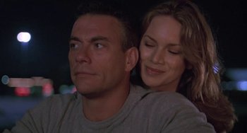 Movie still from “Universal Soldier: The Return” (1999), directed by Mic Rodgers – A man and a woman sitting next to each other in front of lights; Close Up shot, Low angle