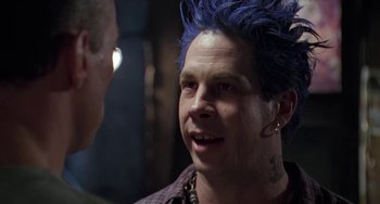 Movie still from “Universal Soldier: The Return” (1999), directed by Mic Rodgers – A man with blue hair talking to another man; Close Up shot, Over the shoulder angle