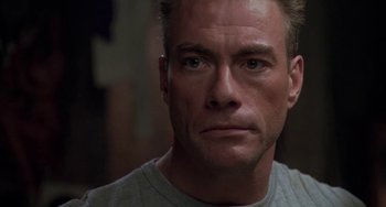 Movie still from “Universal Soldier: The Return” (1999), directed by Mic Rodgers – A person wearing a gray t - shirt; Close Up shot, Low angle