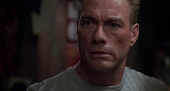 Movie still from “Universal Soldier: The Return” (1999), directed by Mic Rodgers – A person wearing a gray shirt; Close Up shot, Low angle