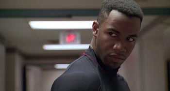 Movie still from “Universal Soldier: The Return” (1999), directed by Mic Rodgers – A person wearing a black shirt; Close Up shot, Over the shoulder angle