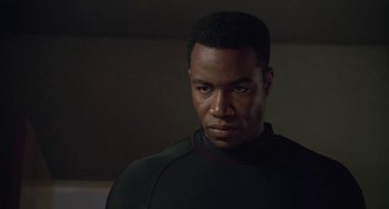 Movie still from “Universal Soldier: The Return” (1999), directed by Mic Rodgers – A man in a black shirt is looking to his left; Close Up shot, Low angle