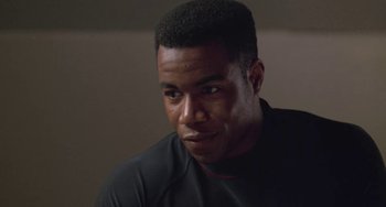 Movie still from “Universal Soldier: The Return” (1999), directed by Mic Rodgers – A person wearing a black shirt; Close Up shot, Over the shoulder angle