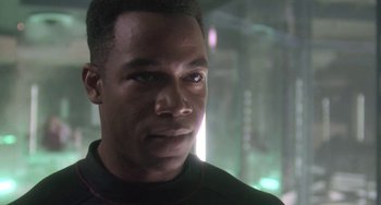 Movie still from “Universal Soldier: The Return” (1999), directed by Mic Rodgers – A person wearing a black shirt; Close Up shot, Over the shoulder angle