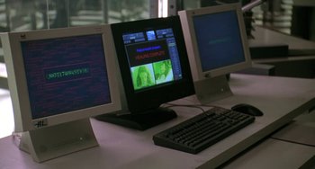 Movie still from “Universal Soldier: The Return” (1999), directed by Mic Rodgers – Three computer monitors and a keyboard on a desk; Extreme Close Up shot, Low angle