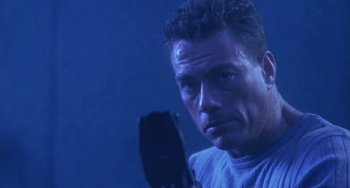 Movie still from “Universal Soldier: The Return” (1999), directed by Mic Rodgers – A person holding a microphone; Close Up shot, Low angle