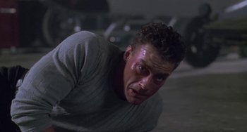 Movie still from “Universal Soldier: The Return” (1999), directed by Mic Rodgers – A person laying on the ground in a room; Close Up shot, Low angle