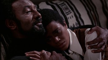 Movie still from “Uptight” (1968), directed by Jules Dassin – A man and a young woman snuggling on a bed; Close Up shot, High angle