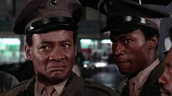 Movie still from “Uptight” (1968), directed by Jules Dassin – A couple of men in military fatigues standing next to each other; Close Up shot, Low angle