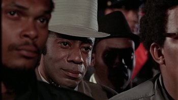 Movie still from “Uptight” (1968), directed by Jules Dassin – A group of men in suits and hats looking at the camera; Close Up shot, Over the shoulder angle