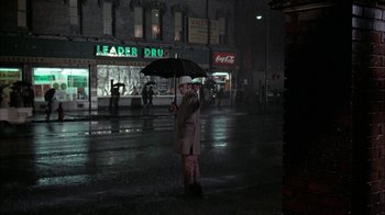 Movie still from “Uptight” (1968), directed by Jules Dassin – A man in a white hat holding an open umbrella; Wide shot, Low angle