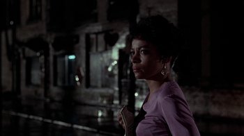 Movie still from “Uptight” (1968), directed by Jules Dassin – A woman standing in the dark with a microphone in her hand; Close Up shot, Over the shoulder angle