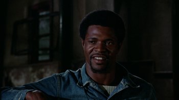 Movie still from “Uptight” (1968), directed by Jules Dassin – A person smiling for the camera; Close Up shot, Low angle