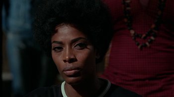 Movie still from “Uptight” (1968), directed by Jules Dassin – A person wearing a black shirt; Close Up shot, Over the shoulder angle