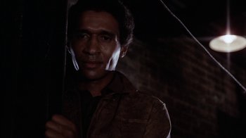 Movie still from “Uptight” (1968), directed by Jules Dassin – A man holding an open umbrella in the dark; Close Up shot, Low angle