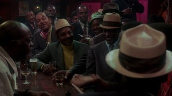 Movie still from “Uptight” (1968), directed by Jules Dassin – A group of men sitting at a table with drinks; Medium shot, High angle