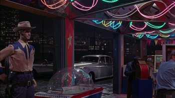 Movie still from “Uptight” (1968), directed by Jules Dassin – A car is parked in front of a building with neon lights; Wide shot, High angle