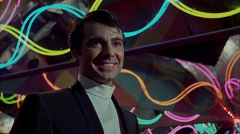 Movie still from “Uptight” (1968), directed by Jules Dassin – A man in a black suit smiling for the camera; Close Up shot, Low angle
