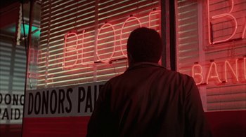 Movie still from “Uptight” (1968), directed by Jules Dassin – A man standing in front of a store window; Medium shot, Low angle