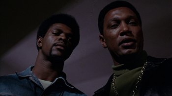Movie still from “Uptight” (1968), directed by Jules Dassin – Two black men standing next to each other in a dark room; Close Up shot, Low angle