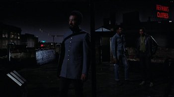 Movie still from “Uptight” (1968), directed by Jules Dassin – A man in a blue suit standing next to another man in a blue suit; Medium shot, Low angle