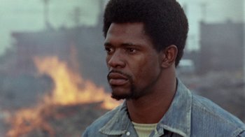 Movie still from “Uptight” (1968), directed by Jules Dassin – A person wearing a jean jacket; Close Up shot, Low angle