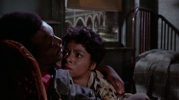 Movie still from “Uptight” (1968), directed by Jules Dassin – An older man and a younger woman sitting on a couch; Close Up shot, Over the shoulder angle