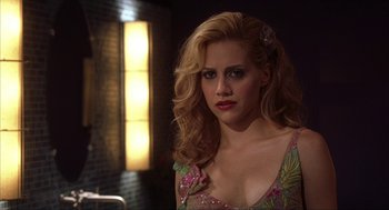 Movie still from “Uptown Girls” (2003), directed by Boaz Yakin – A woman with blonde hair wearing a pink and green dress; Close Up shot, Over the shoulder angle