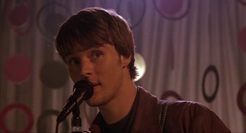 Movie still from “Uptown Girls” (2003), directed by Boaz Yakin – A young man is singing into a microphone; Close Up shot, Over the shoulder angle