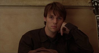 Movie still from “Uptown Girls” (2003), directed by Boaz Yakin – A man sitting on top of a wooden bench; Close Up shot, High angle