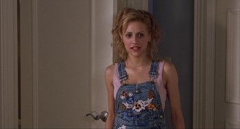 Movie still from “Uptown Girls” (2003), directed by Boaz Yakin – A young woman in overalls standing in front of a door; Close Up shot, Over the shoulder angle