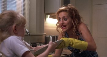 Movie still from “Uptown Girls” (2003), directed by Boaz Yakin – A woman is holding a remote in her hand and looking at another woman; Close Up shot, Over the shoulder angle