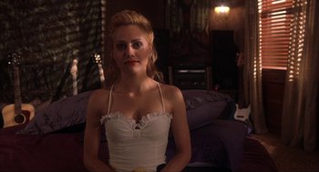Movie still from “Uptown Girls” (2003), directed by Boaz Yakin – A woman in a white top is posing for a picture; Close Up shot, Over the shoulder angle