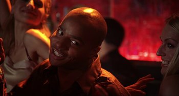 A man smiling for the camera in a dark room